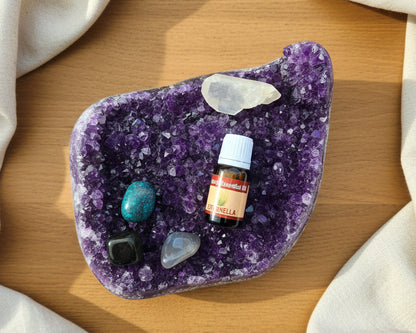 Citronella essential oil bottle on a raw amethyst crystal