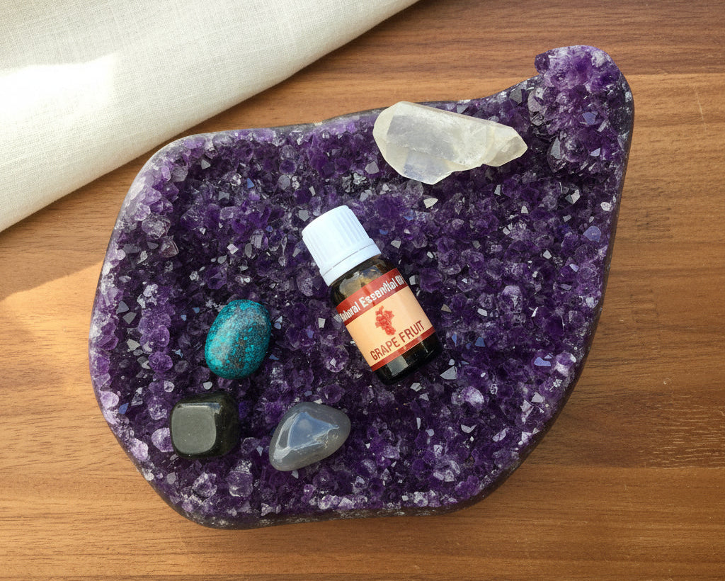 Grapefruit essential oil bottle on a raw amethyst crystal