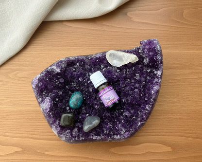 Lavender essential oil bottle on a raw amethyst crystal