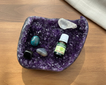 Lemongrass essential oil bottle on a raw amethyst crystal