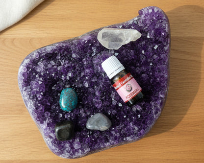 Rosemary essential oil bottle on a raw amethyst crystal